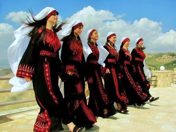 Young women in Palestinian Thobes doing the traditional dance - Dabka